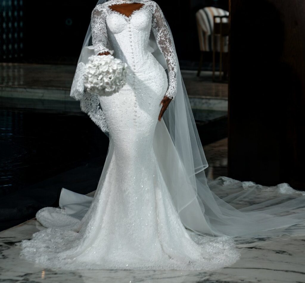 Woman in a white lace mermaid wedding dress holding a white bouquet