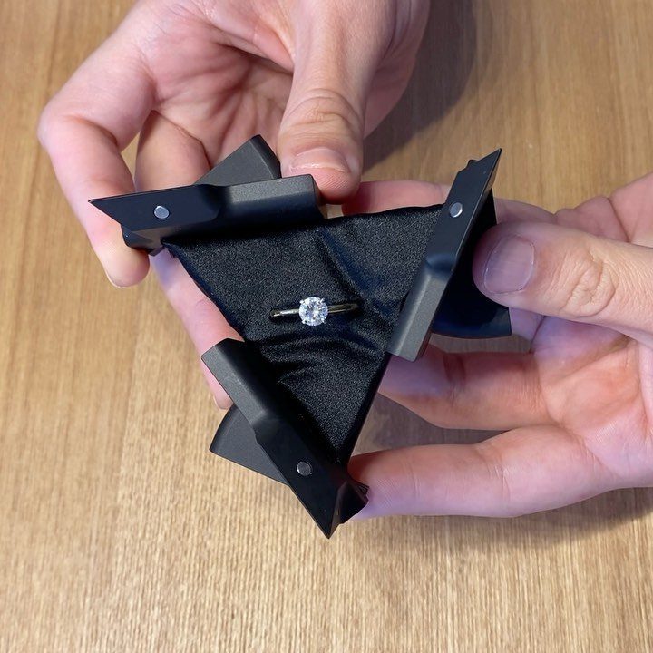 Geometric black engagement ring box held open revealing a diamond ring inside