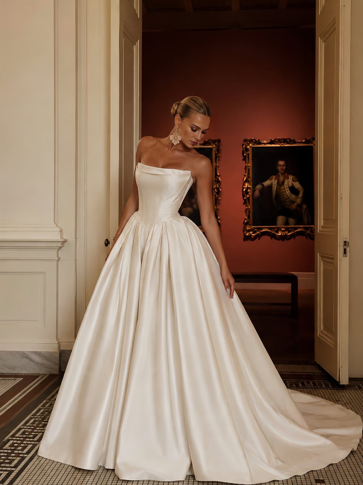 Woman in a white strapless satin wedding dress standing in an art gallery