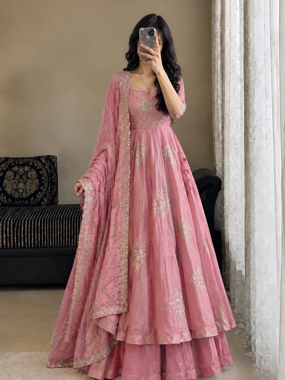 Woman wearing a pink embroidered lehenga choli and dupatta for a wedding guest outfit.